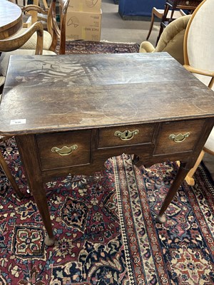 Lot 636 - A Georgian oak three drawer low boy raised on...