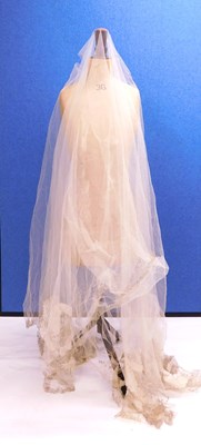 Lot 194 - An extensive net lace veil with aplique satin...